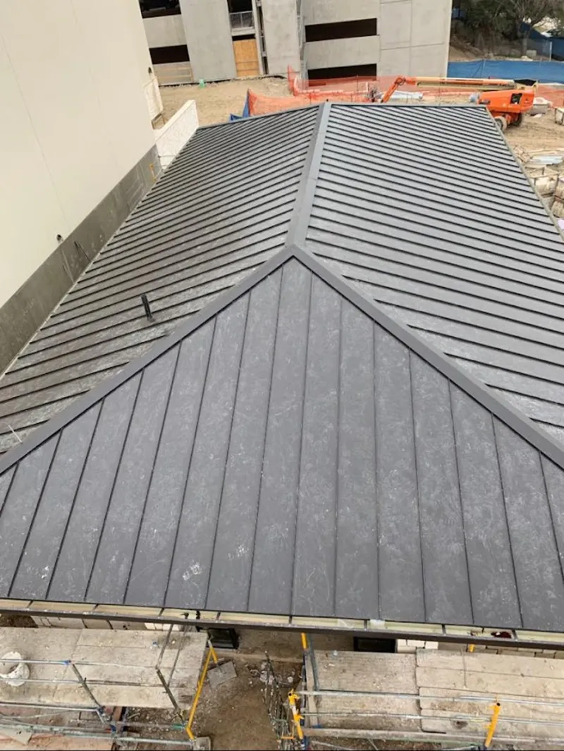 Commercial metal roof construction with crane equipment in Attleboro